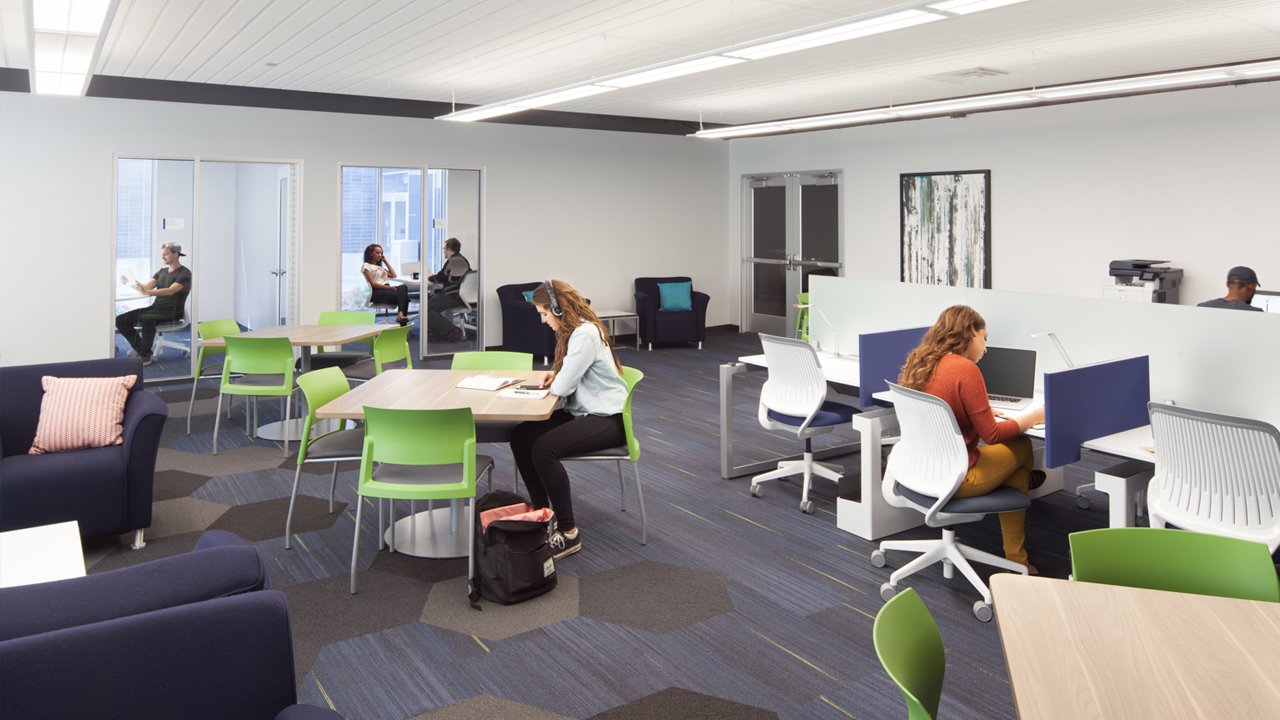 students at desks and tables in shared coworking area