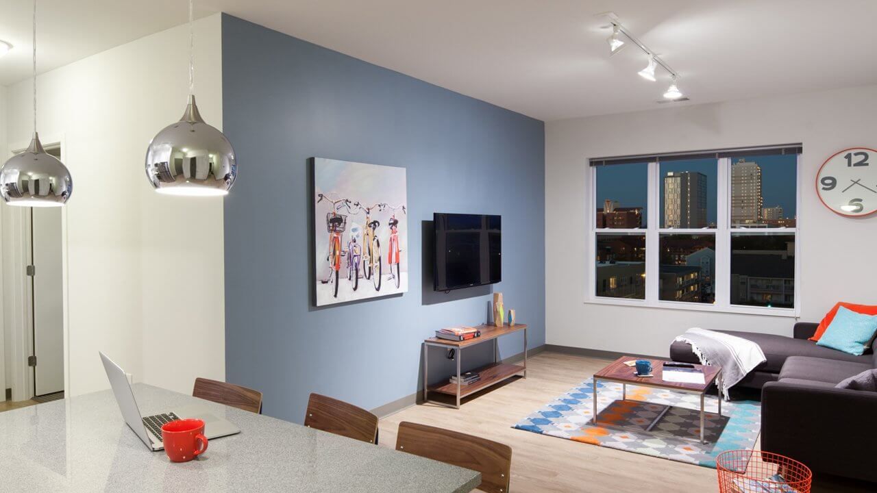 open apartment living and dining room with windows with views of the city