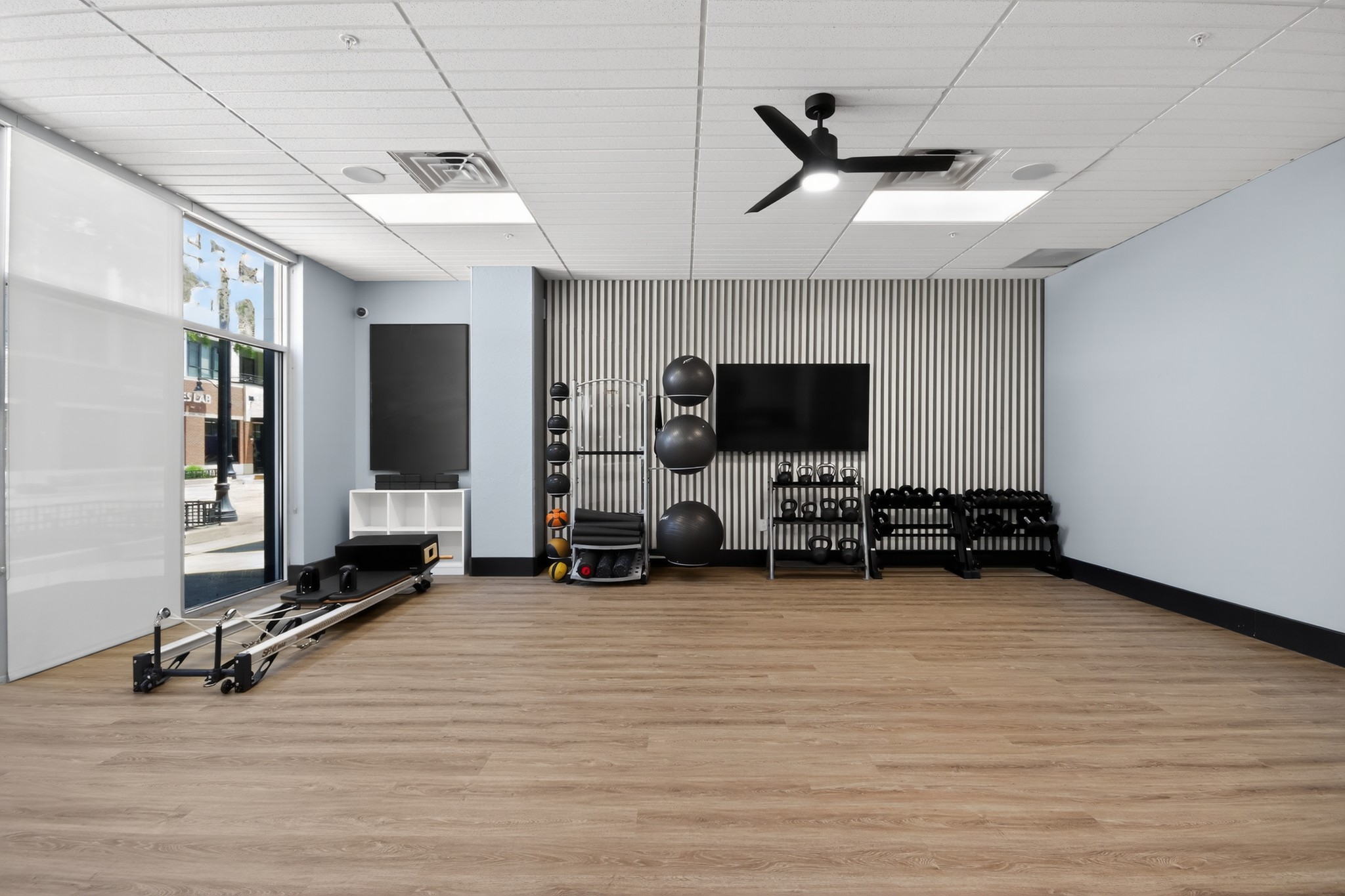 Yoga room with free weights and Pilates reformer machine